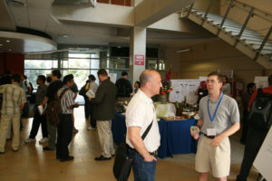 Attendees standing near posters on easels and mingling at the CNS Research Review, July 16-17, 2008 Poster Session in CSE Foyer