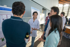 Attendees standing near posters on easels and mingling at the CNS Research Review October 22, 2014 Poster Session