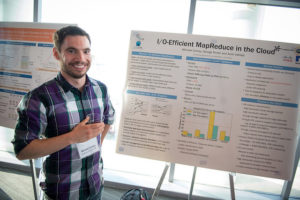 Attendees standing near posters on easels and mingling at the CNS Research Review October 22, 2014 Poster Session