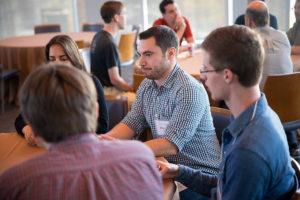 Attendees sitting at tables eating lunch at CNS Research Review, October 13, 2016, at the Great Hall, UCSD