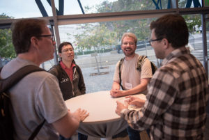 Attendees standing near posters on easels and mingling at the CNS Research Review 2017 Poster Session