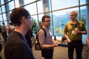 Attendees standing near posters on easels and mingling at the CNS Research Review 2017 Poster Session